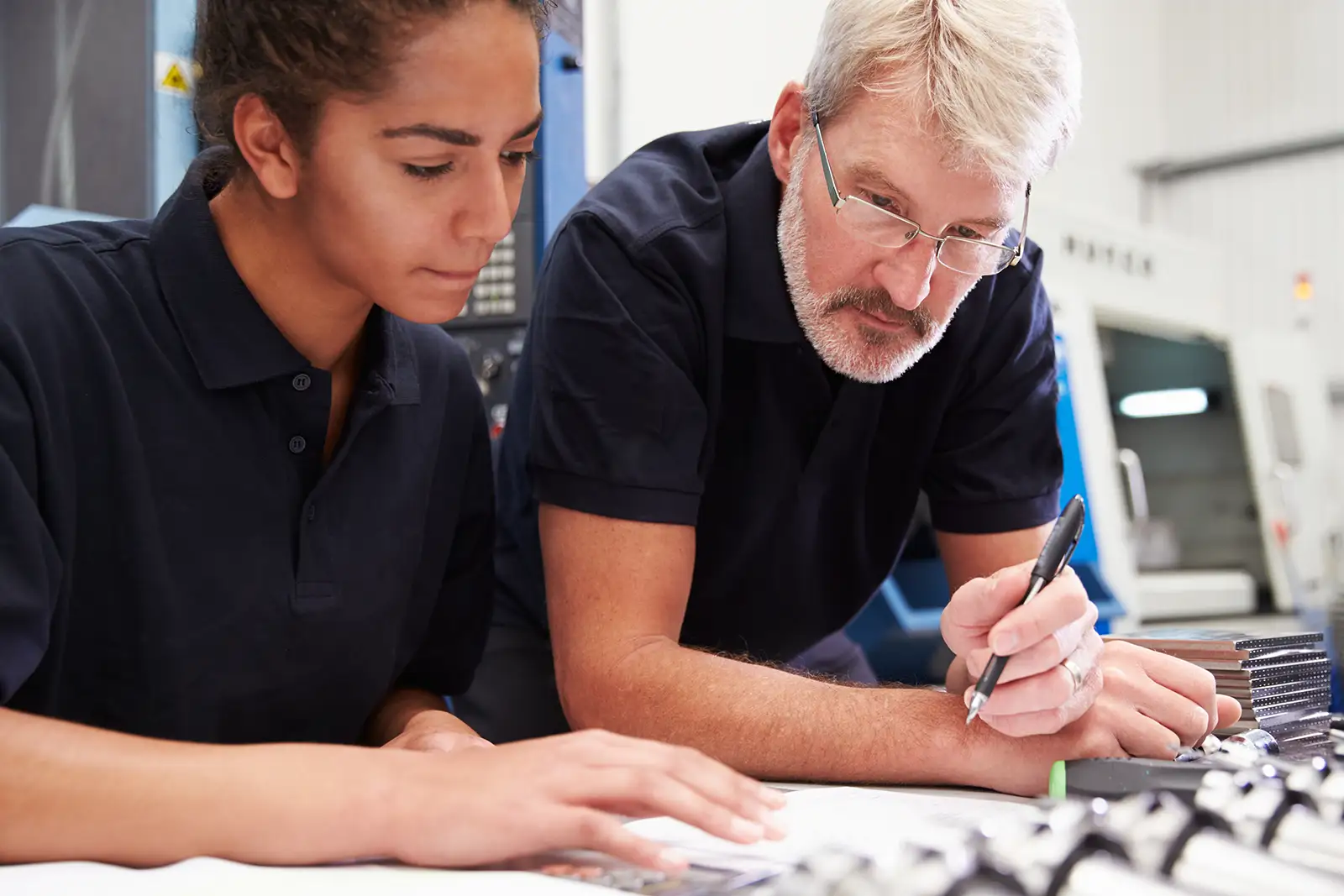 Photo of an engineer and apprentice planning CNC machinery project