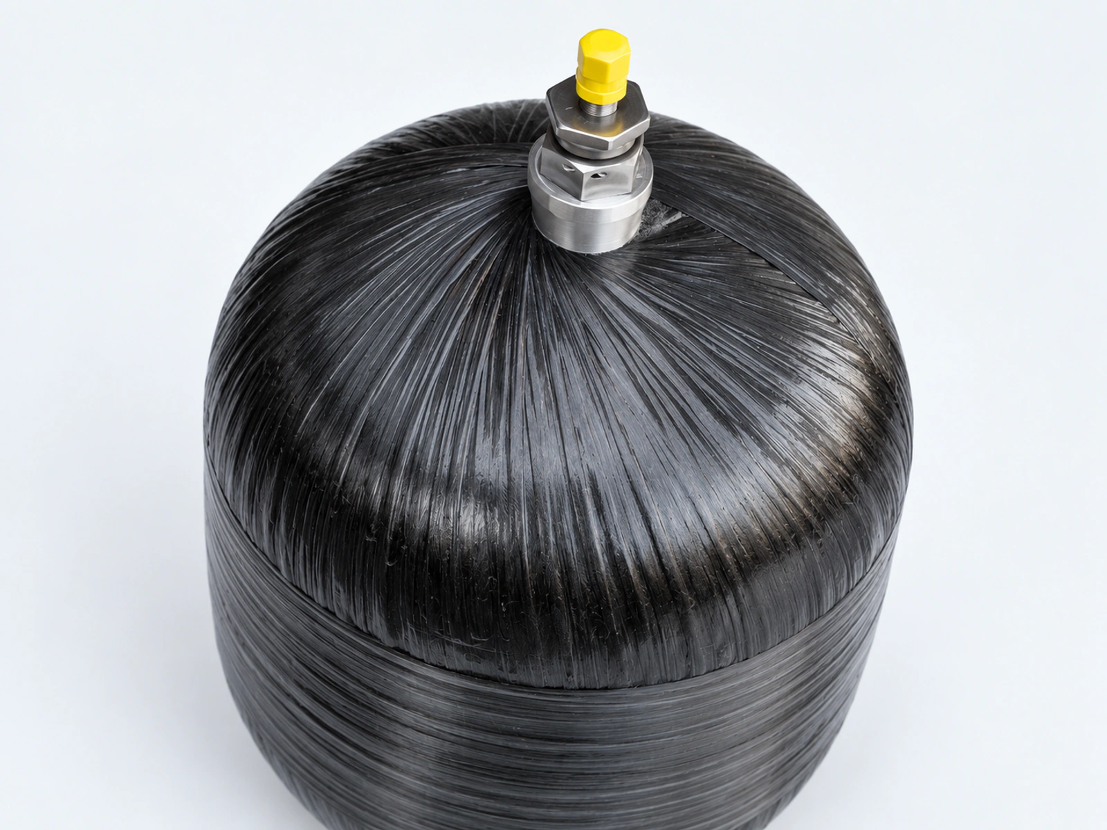 Close view of a composite accumulator dome and metal connection with a yellow protective cap.