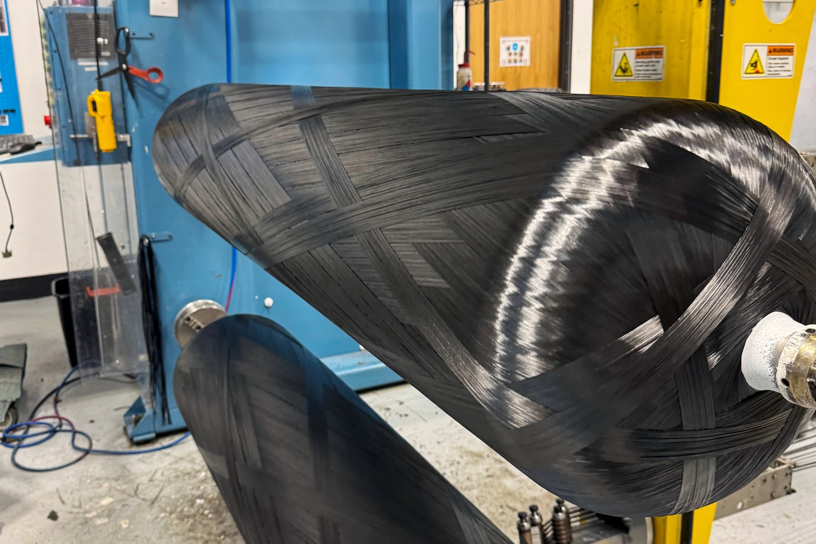Close view of the original carbon-fiber winding and vessel interface on Steelhead manufacturing equipment.