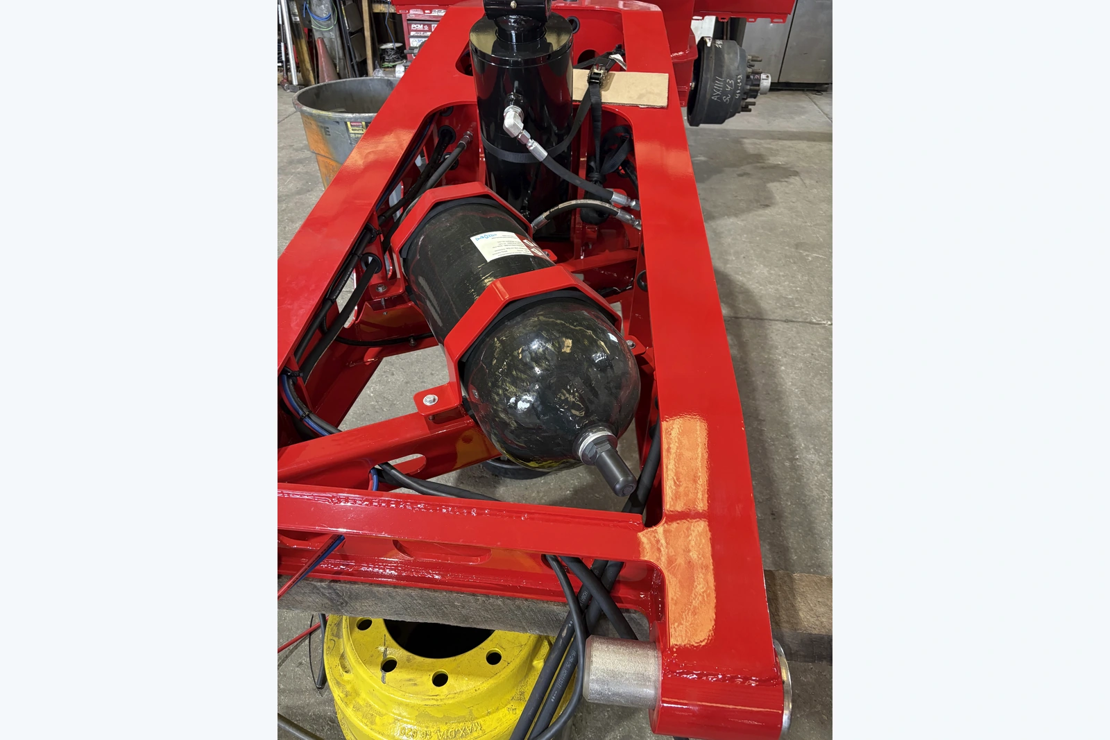 Customer equipment installation showing a bottom-repairable PowerMax accumulator, hydraulic lines and mounting frame