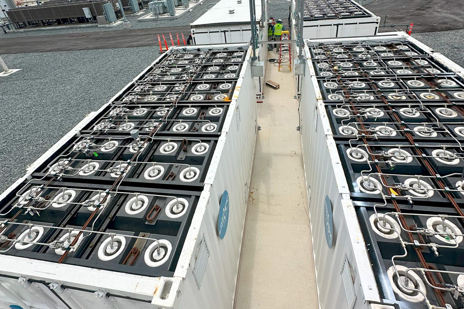 Top-down view of HydrogenCube storage module revealing rows of composite pressure vessels and stainless steel gas manifolds inside a containerized frame.