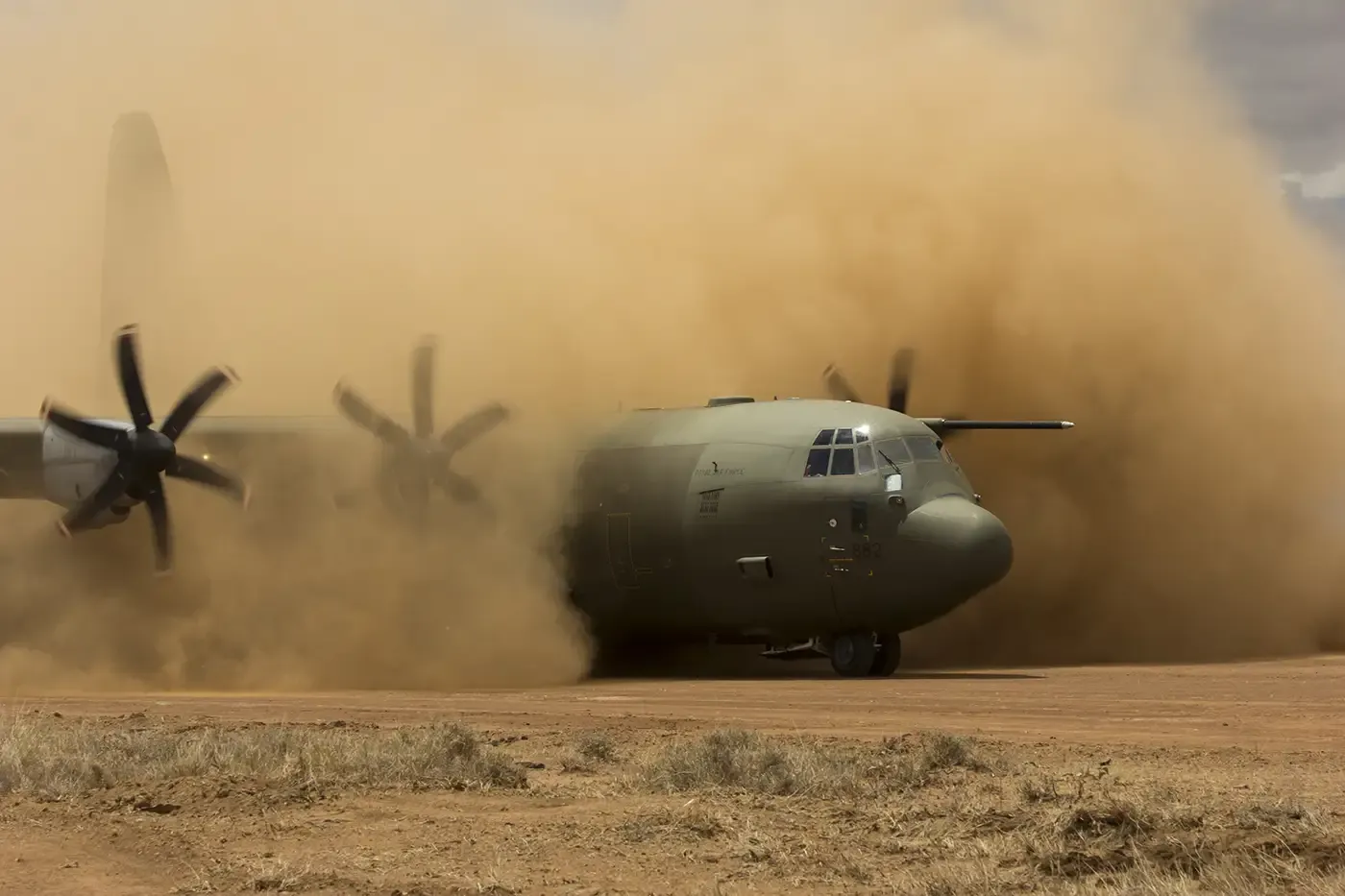 Military transport aircraft landing on a remote airstrip, symbolizing mobile field labs that require reliable delivery of specialty gases for scientific and diagnostic operations.
